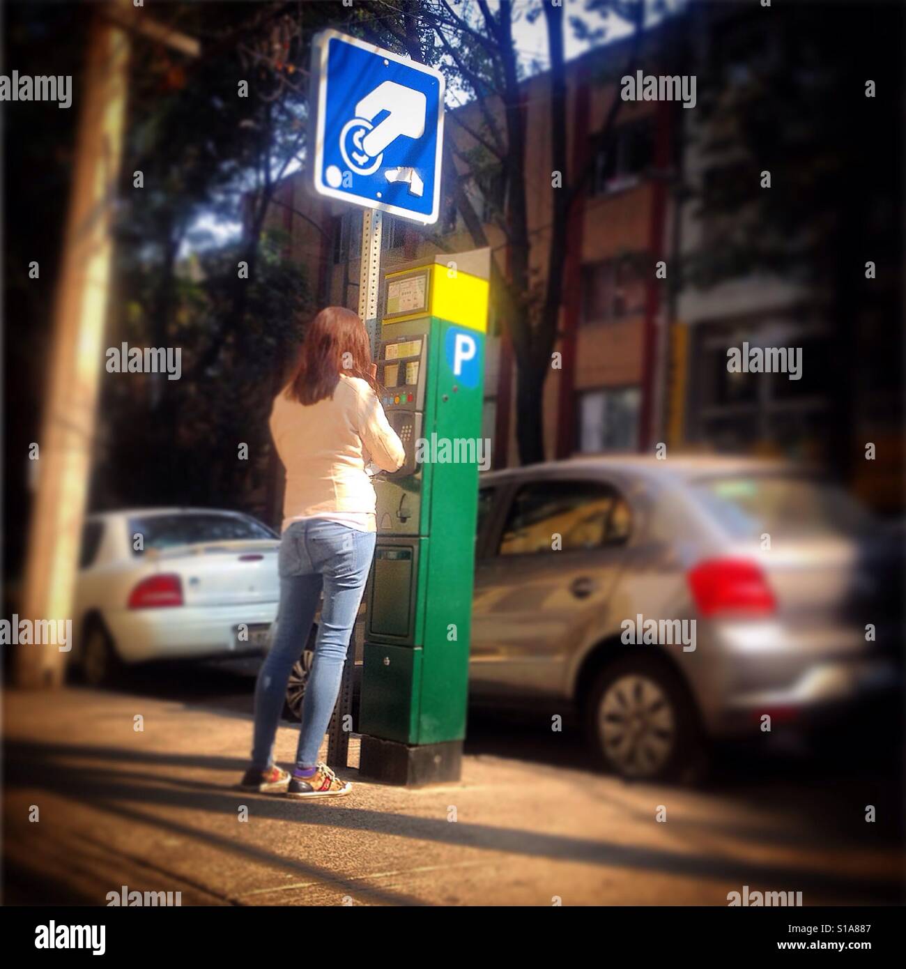 Eine Frau zahlt für Parken Sie ihr Auto in einer öffentlichen Straße in Mexico City, Mexiko Stockfoto