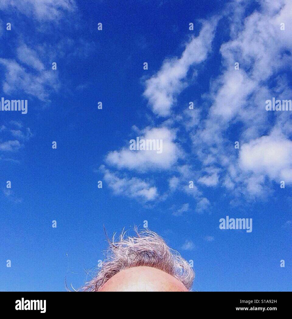 Oben auf den Kopf des Mannes auf einem sehr klaren blauen Himmel mit Wolken Stockfoto