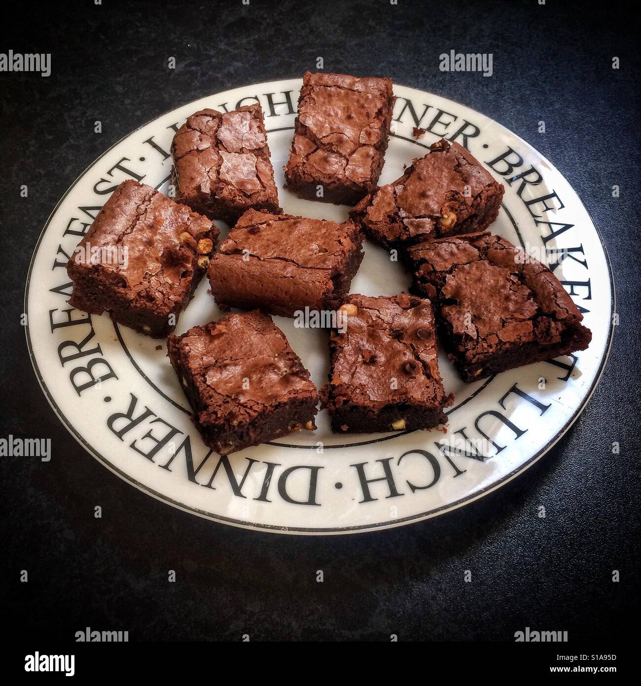 Schokoladen-Brownies auf einem weißen Teller vor einem dunklen Hintergrund. Stockfoto
