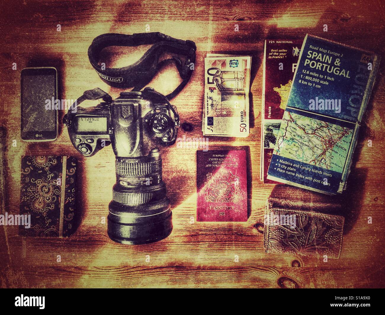Elemente zu reisen. DSLR Kamera, Pass, Euro, Karten von Frankreich und Spanien, Handy / Kamera, Notizblock und Stift - Smartphone-aufgenommenes Stockfoto