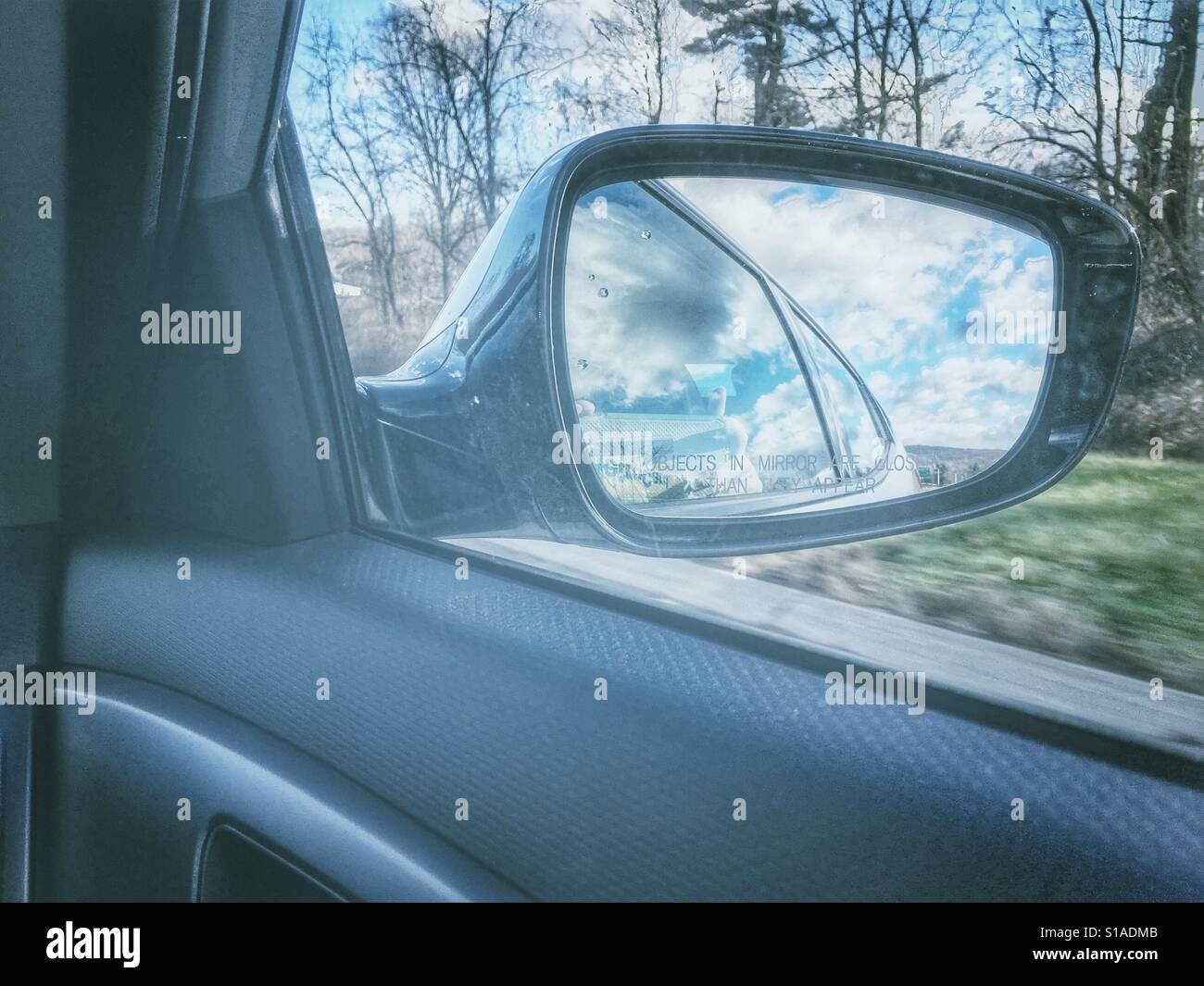 Fernweh auf der Straße Reise Retro-Vintage-Look Auto Auto Spiegel mit blauem Himmel Cumulus Wolken Frau Hand Reflexion nehmen mobile Foto Iphoneography Reisekonzept mit Textfreiraum. - Smartphone-aufgenommenes Stockfoto