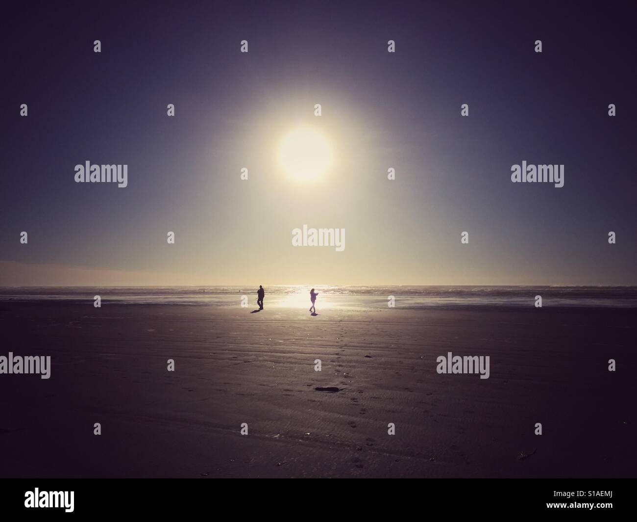 Paar genießt Wintersonne am Strand auf der Olympic Peninsula Stockfoto