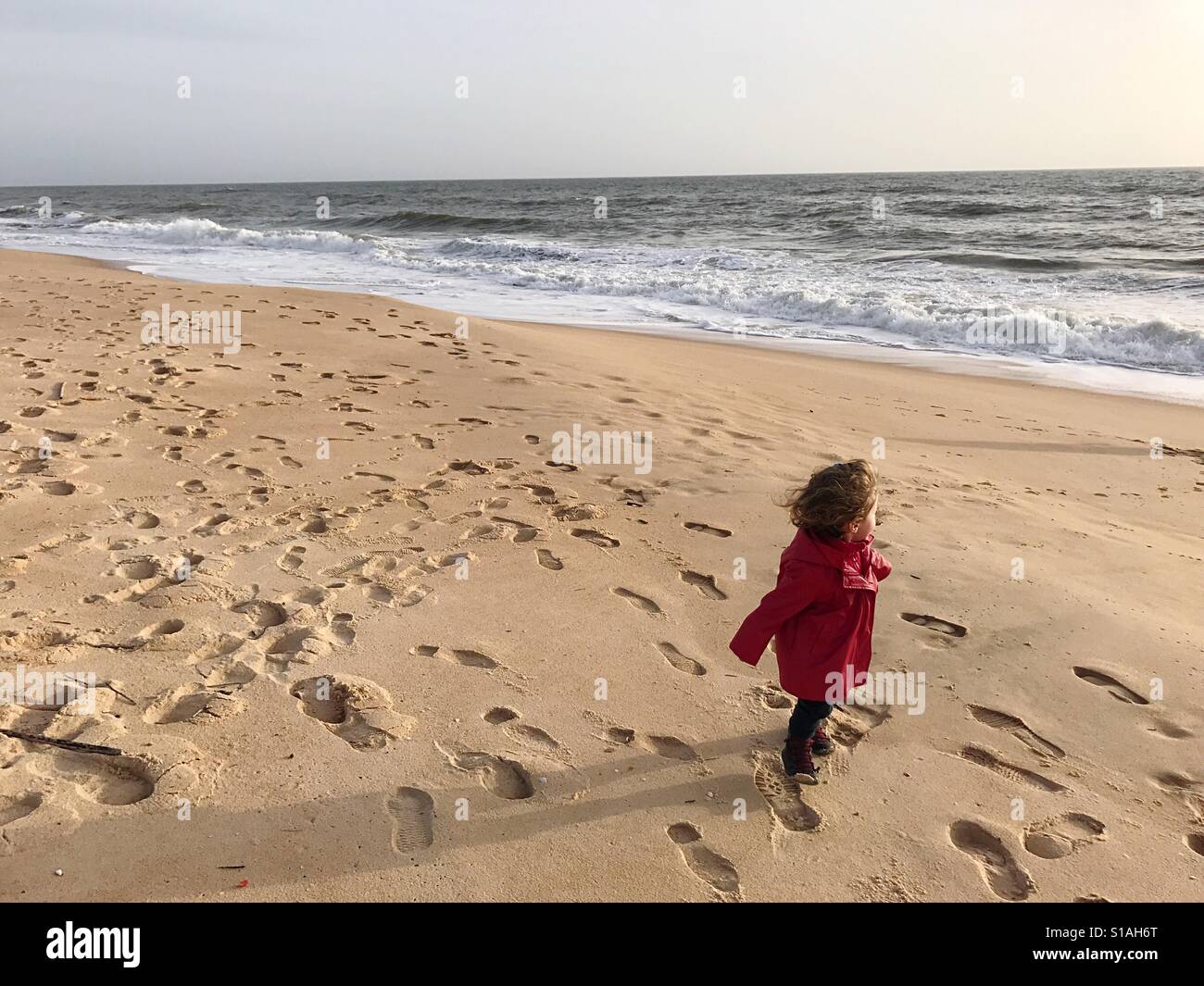 Glückliches Kind am Strand im Winter Faro Algarve Portugal Stockfoto