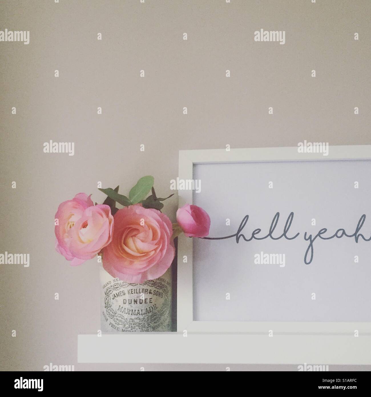 Hölle ja Typografie print und Blumen auf einem Regal Stockfoto