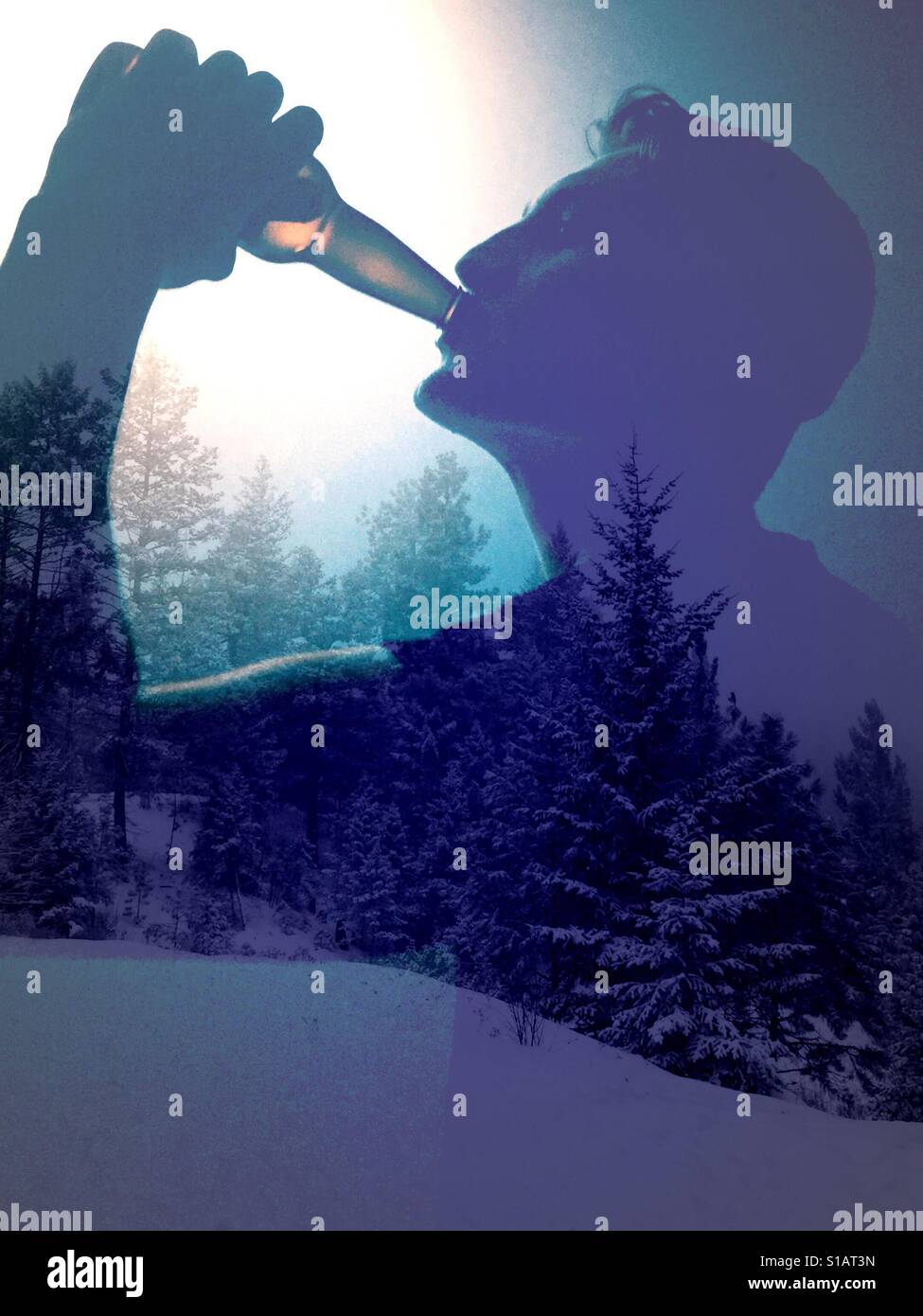 Doppelbelichtung Bild des jungen Mannes ein kaltes Getränk aus einer Flasche und Schnee bedeckt Bäume. Stockfoto