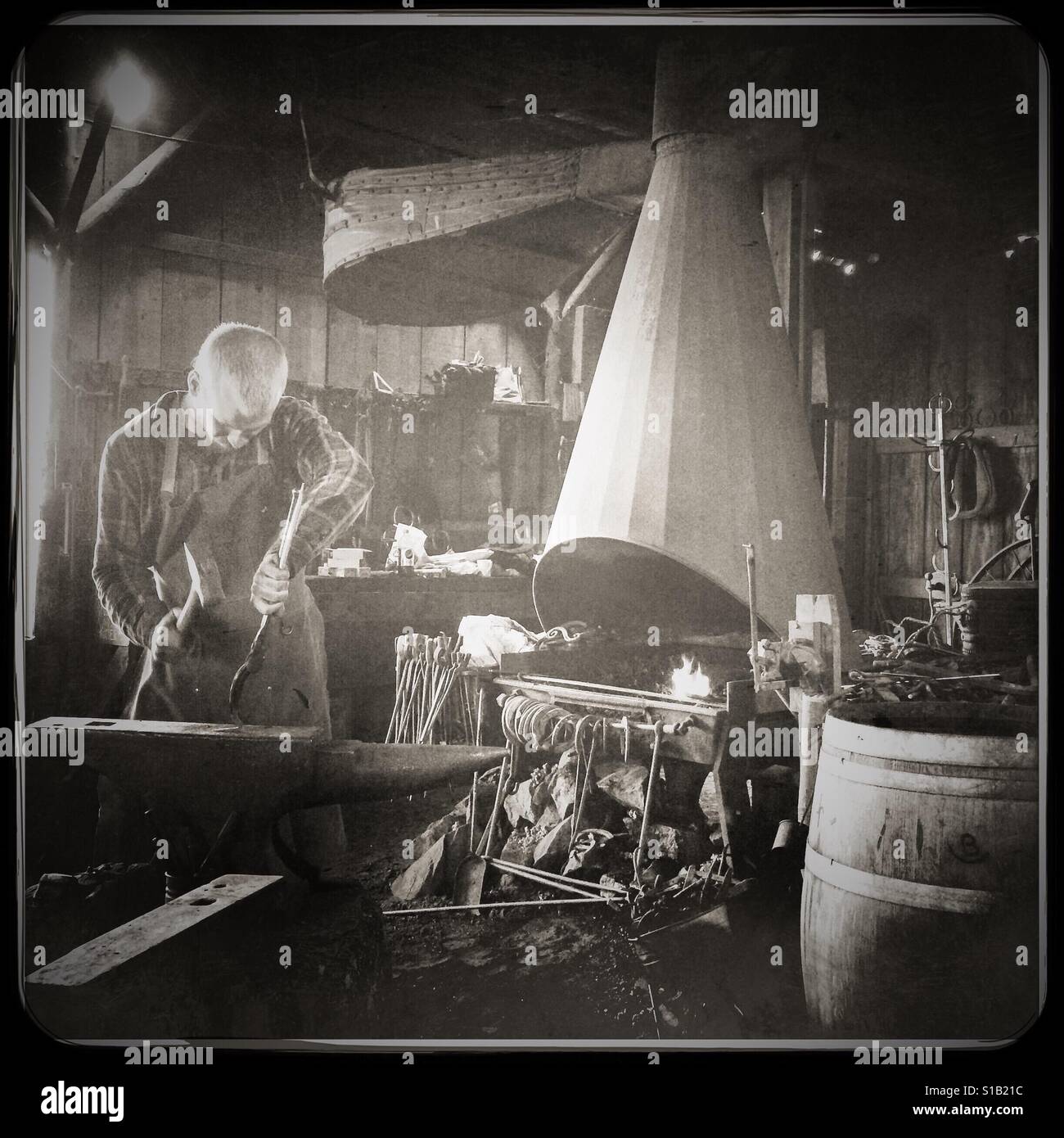 Ein Schmied arbeitet in seiner Werkstatt an der Main Street. Columbia State Historic Park, Columbia, Tuolumne County, Kalifornien, USA - Smartphone-aufgenommenes Stockfoto