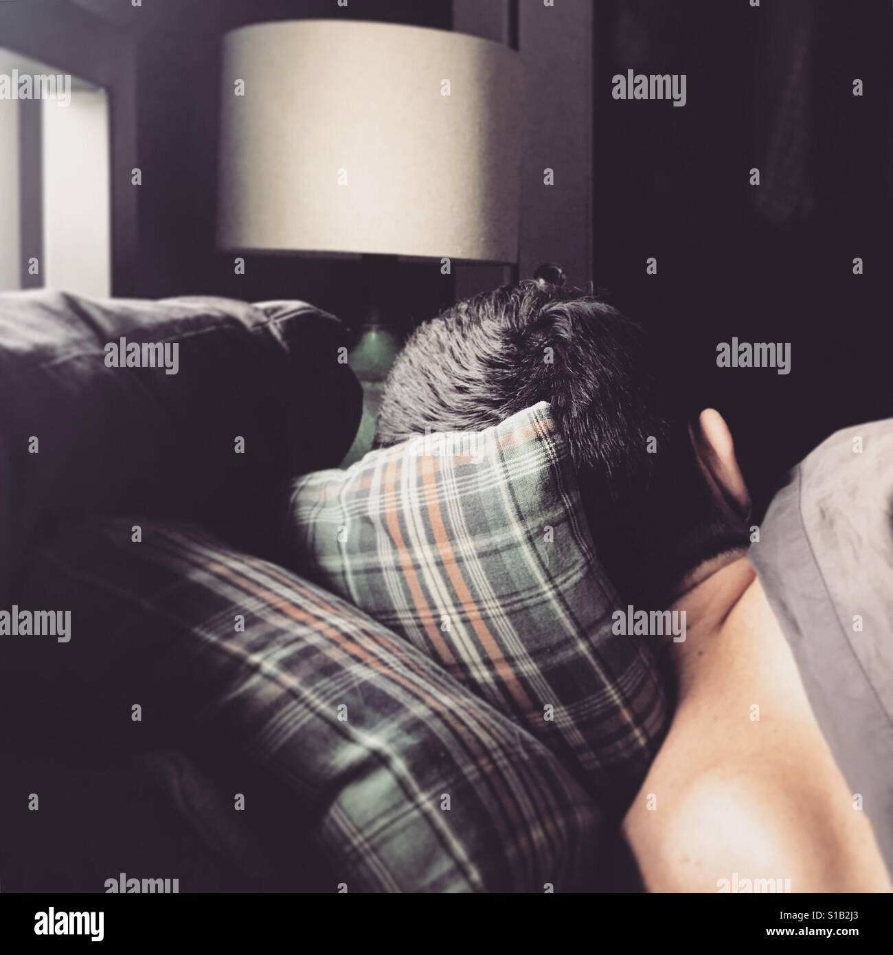Mann schläft auf karierten Kissen Stockfoto