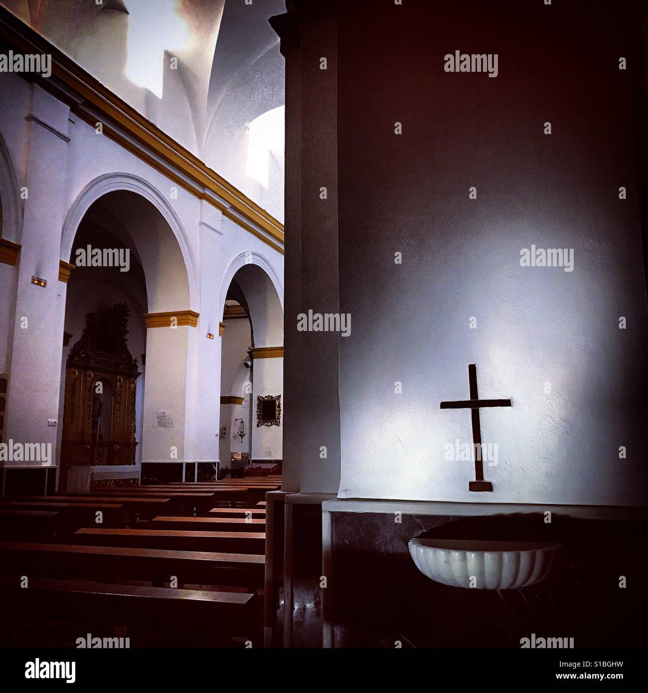 Ein Kreuz beleuchtet in einer Kirche in Prado del Rey, Sierra de Cadiz, Andalusien, Spanien Stockfoto