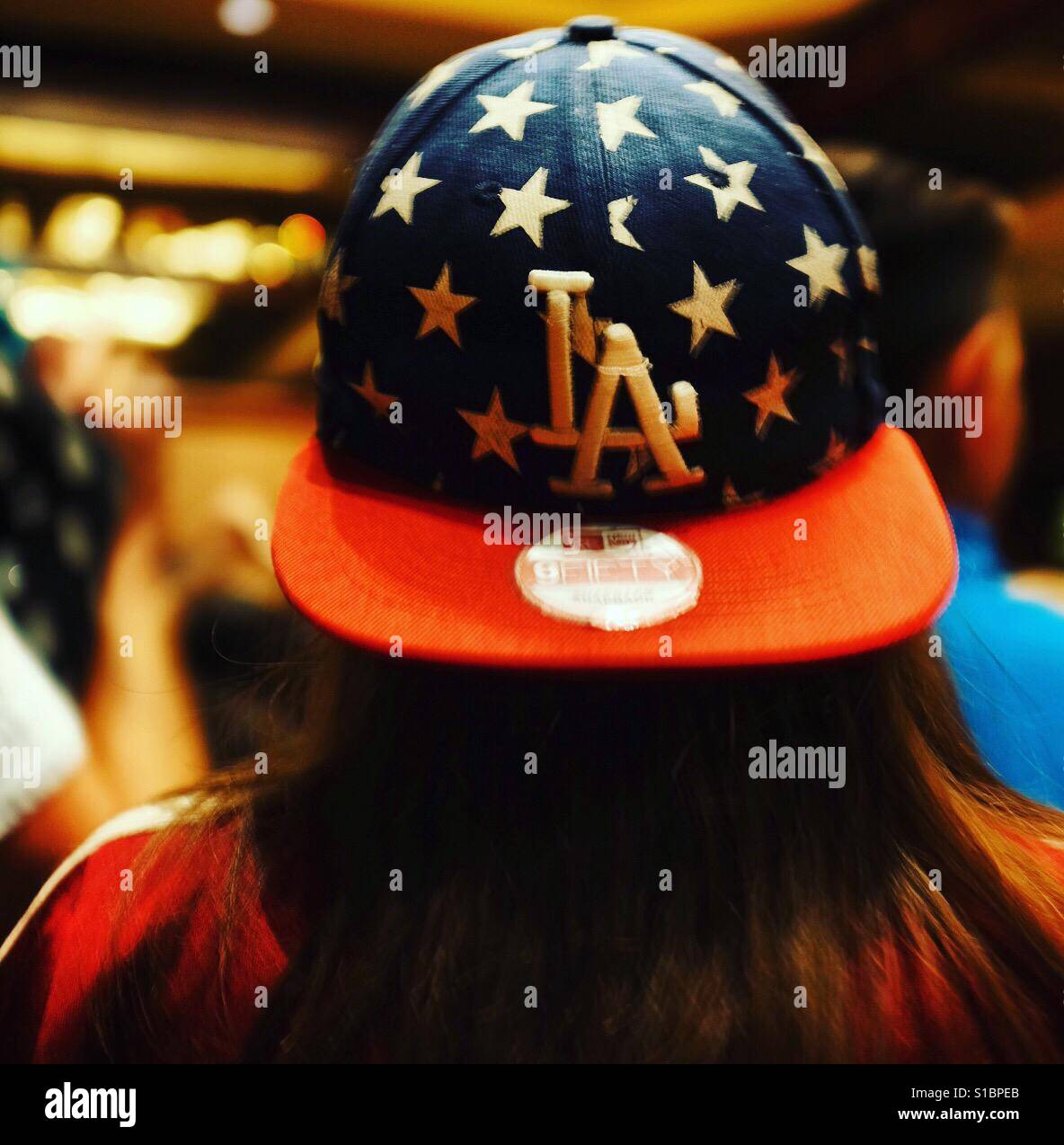 Mädchen mit langen Haaren tragen eine zurück zur vorderen LA-Baseball-Cap mit Sternen Stockfoto