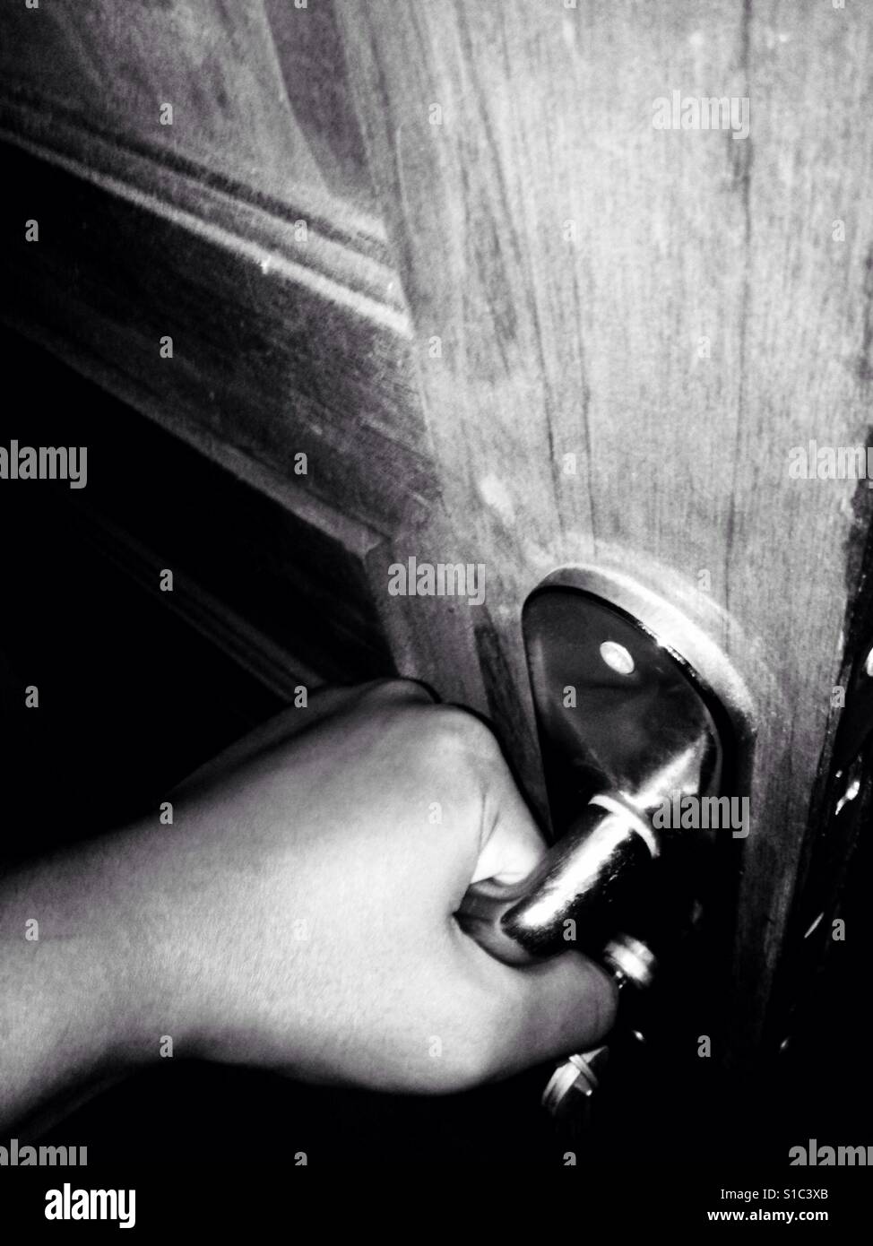 Hand öffnen eine Holztür - schwarz / weiß Stockfoto
