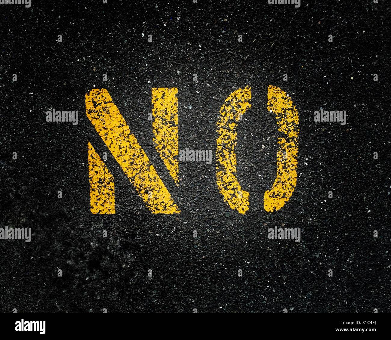Gelb lackierte Straße Kennzeichnung Zeichen auf schwarzem Asphalt Darstellung das Wort Nein. Stockfoto