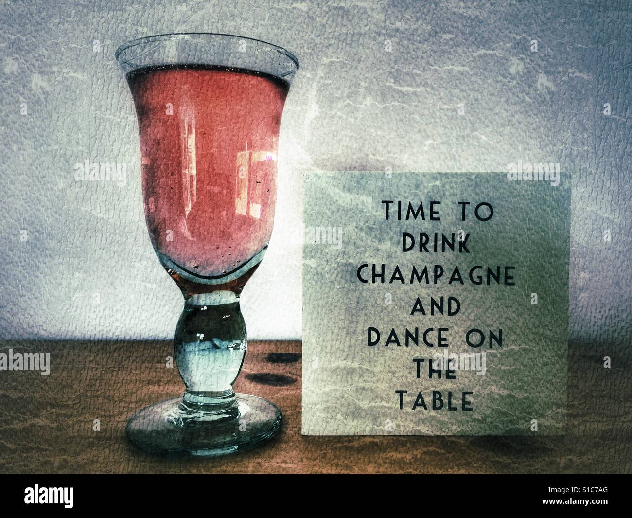 Glas Champagner und es ist Zeit, trinken Champagner und Tanz auf dem Tisch. - Smartphone-aufgenommenes Stockfoto