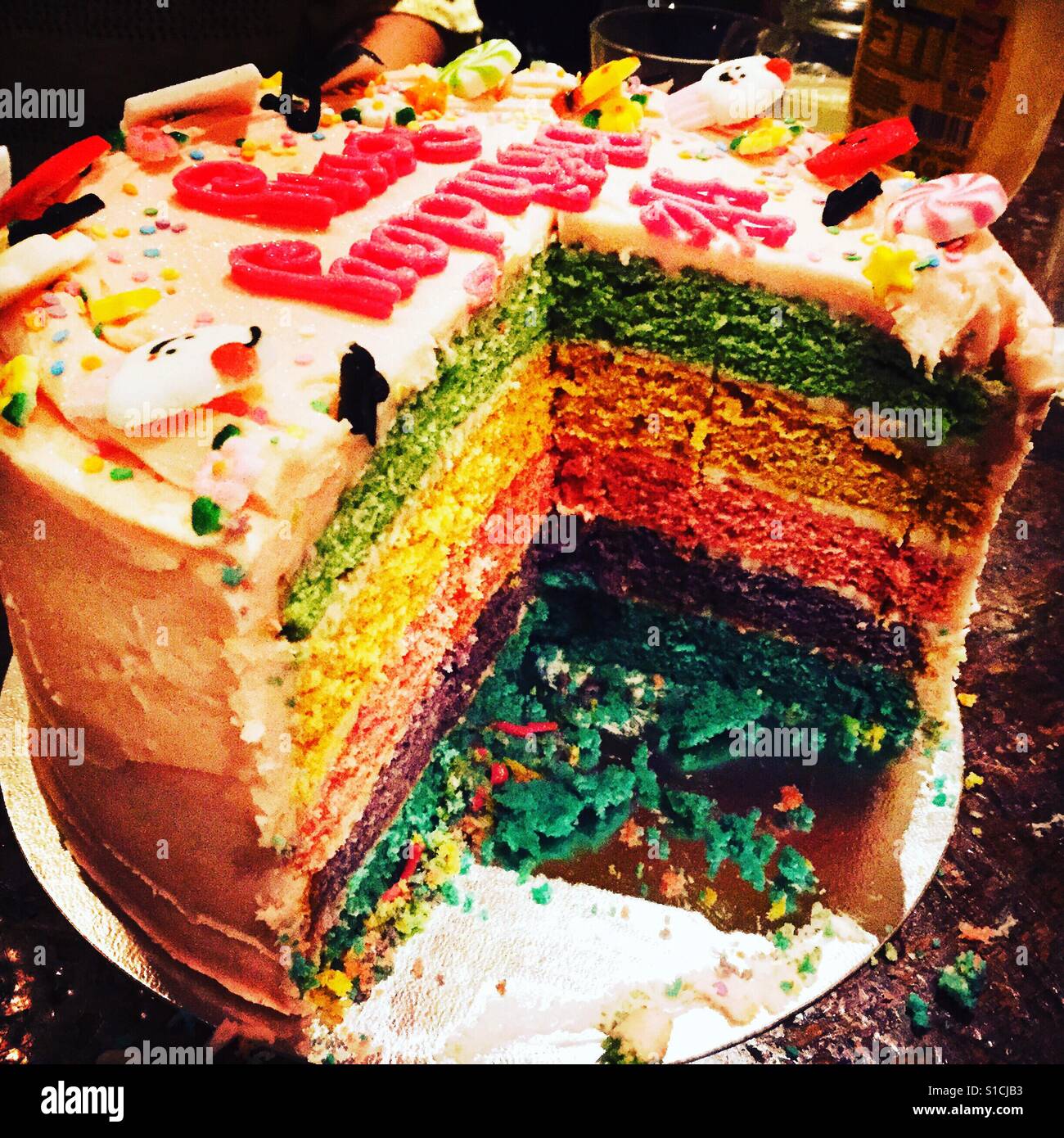 Einen Schnitt Regenbogen-Geburtstagskuchen Stockfoto