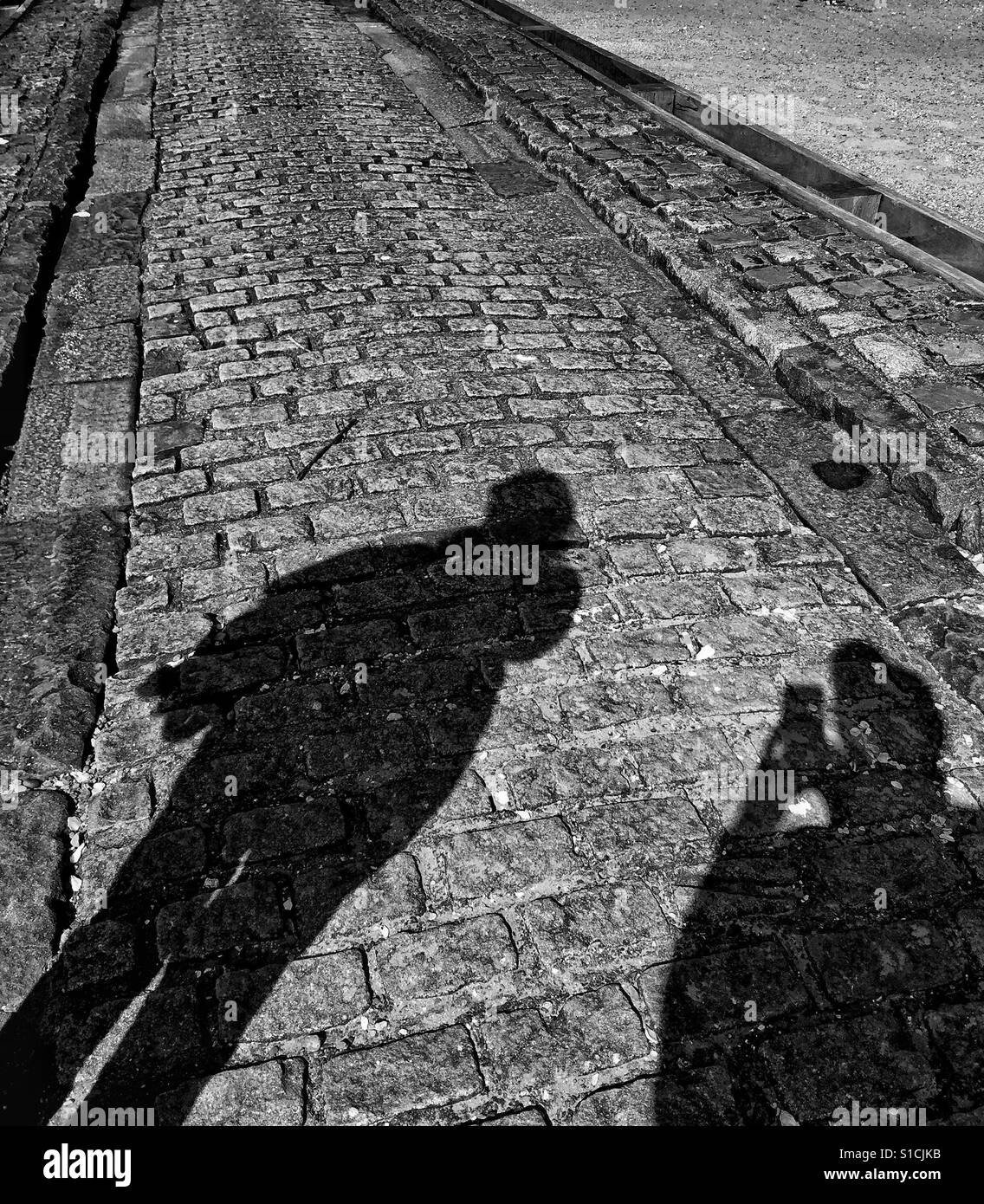 Schatten auf Kopfsteinpflaster - Smartphone-aufgenommenes Stockfoto