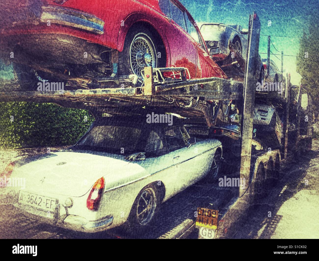 Autos, darunter einen 1973 MGB Roadster auf einen Autotransporter verladen. - Smartphone-aufgenommenes Stockfoto