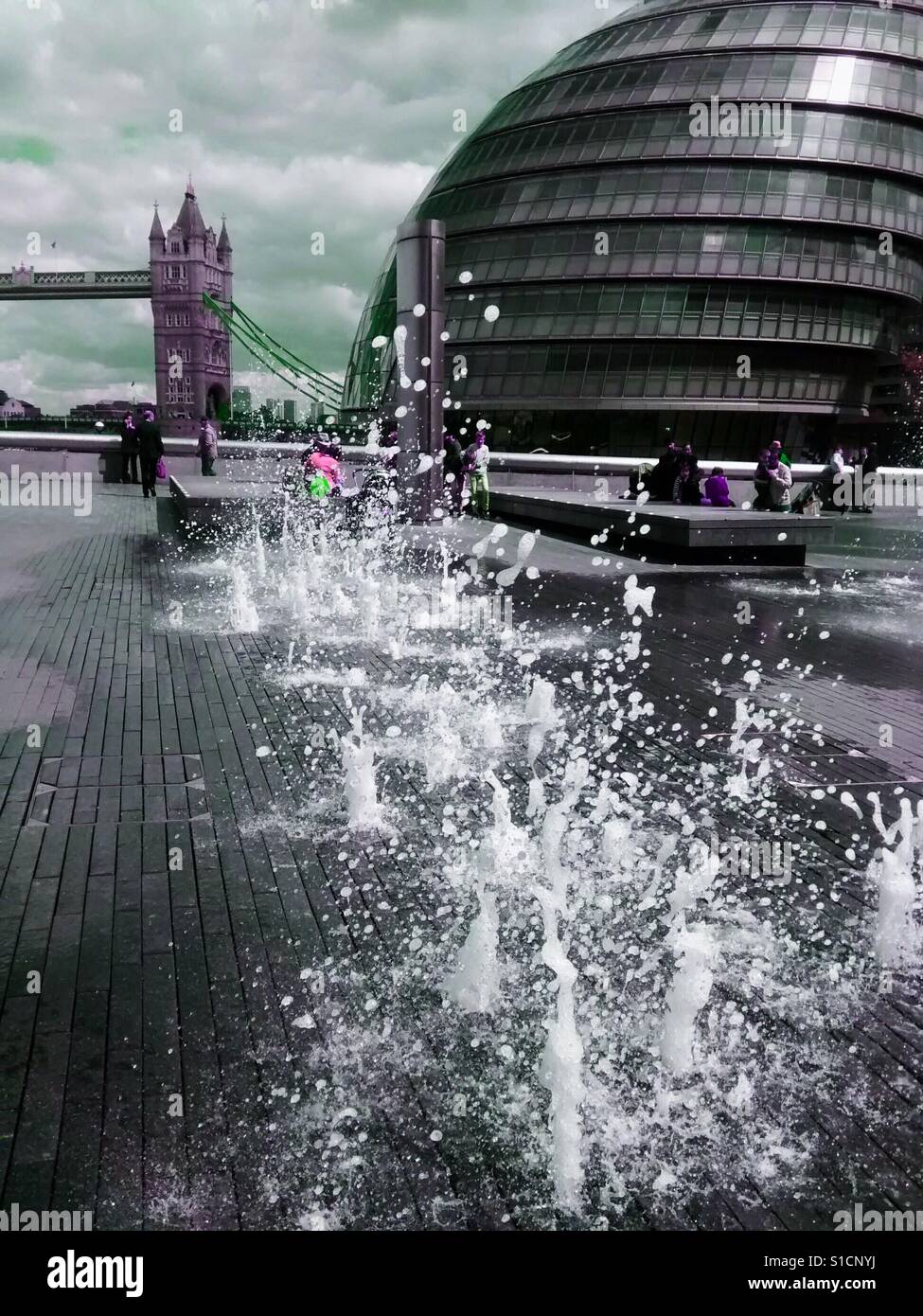 Spielen im Wasser Wasserspiele vor der Tower Bridge und die Bürgermeister Building, City Hall, London, Großbritannien - Smartphone-aufgenommenes Stockfoto