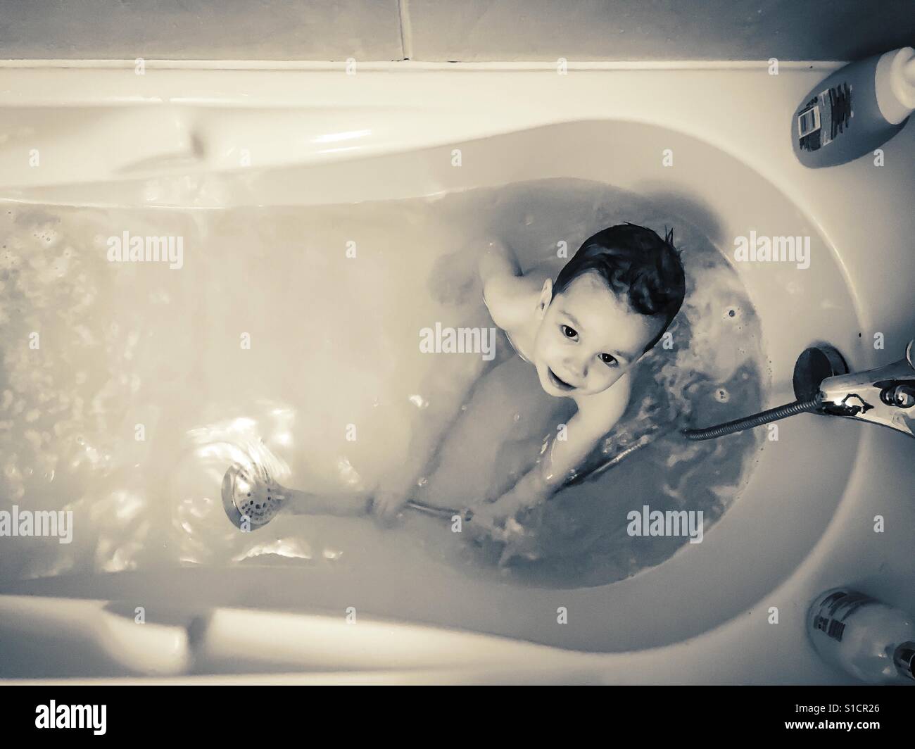 Schwarz / weiß Foto von Baby Boy ein Bad zu nehmen Stockfoto