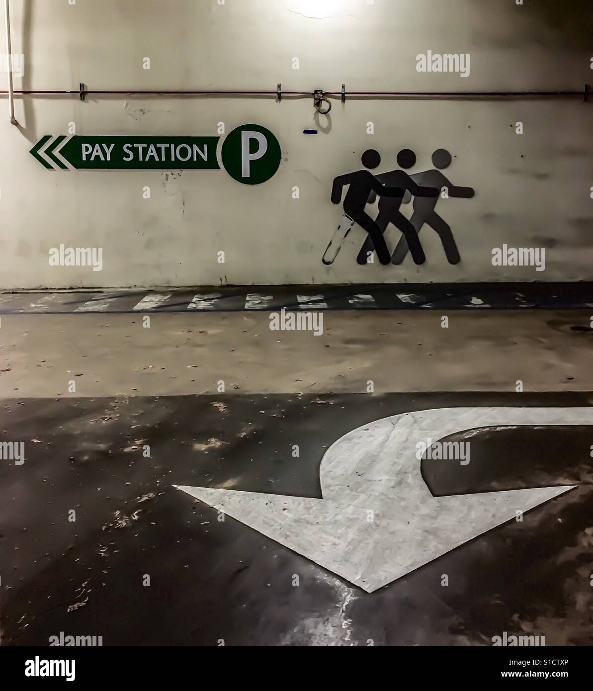 Fußgängerüberweg Warnung Figuren auf Wand, als ob running away von Pay-station Stockfoto