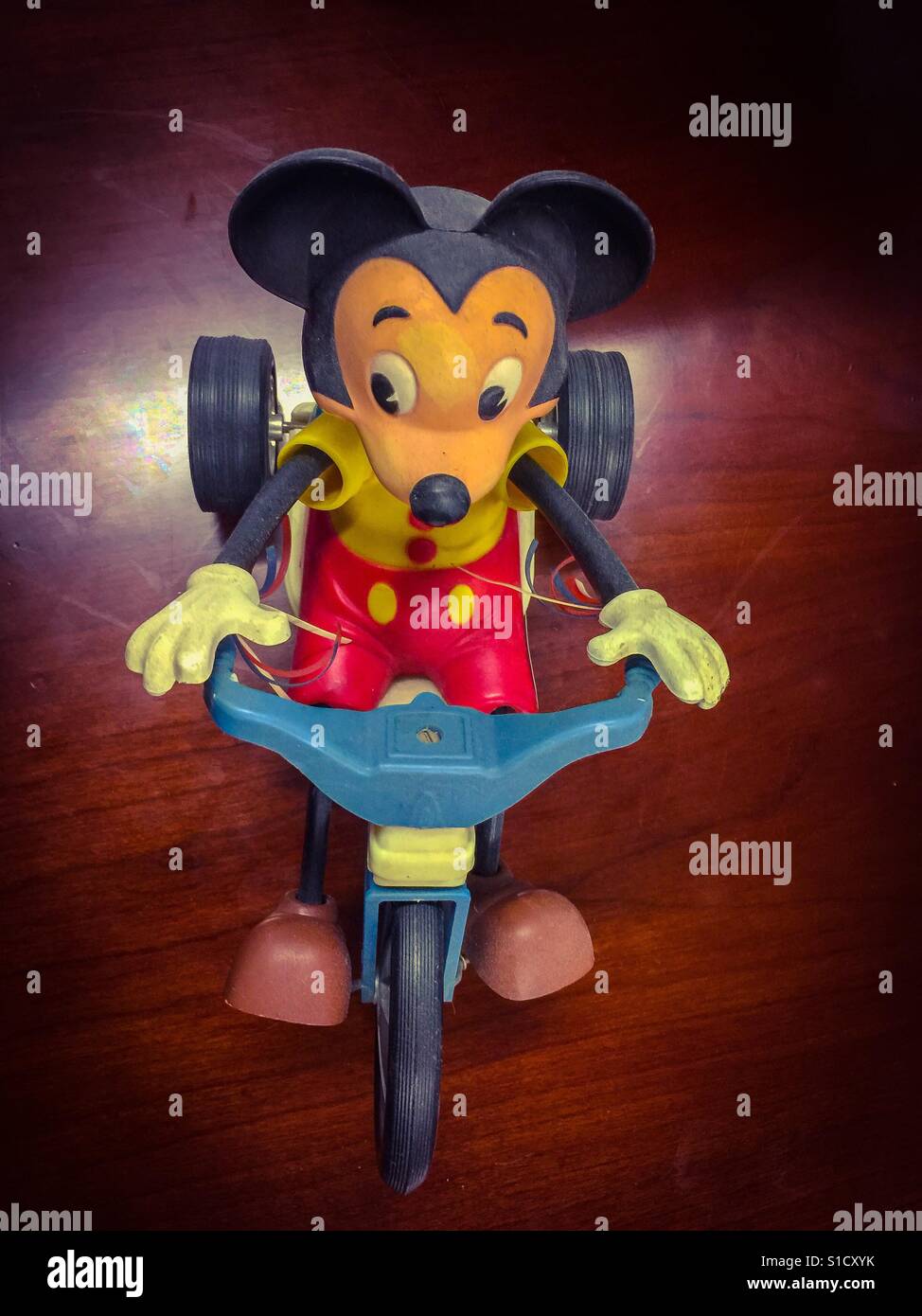 Mickey Mouse auf einem Dreirad. Ein beliebtes Spielzeug aus einer früheren Ära. Immer noch ein lebhafter, heiter Geist. Sorglos. Verspielt. Die berühmteste Maus der Welt. Stockfoto
