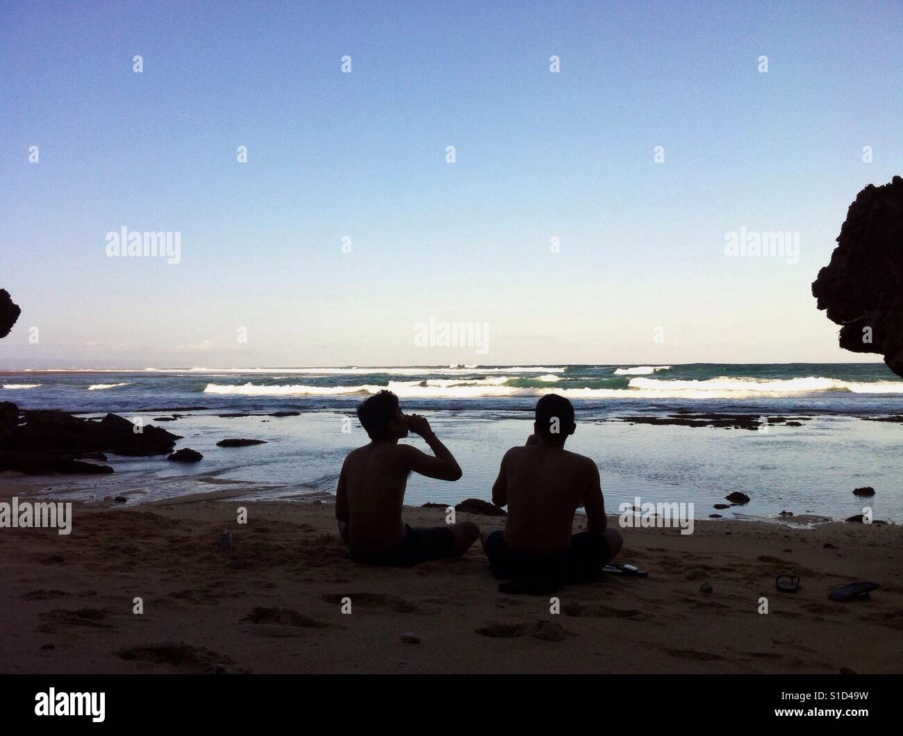 Bier trinken mit Freund am Strand Stockfoto