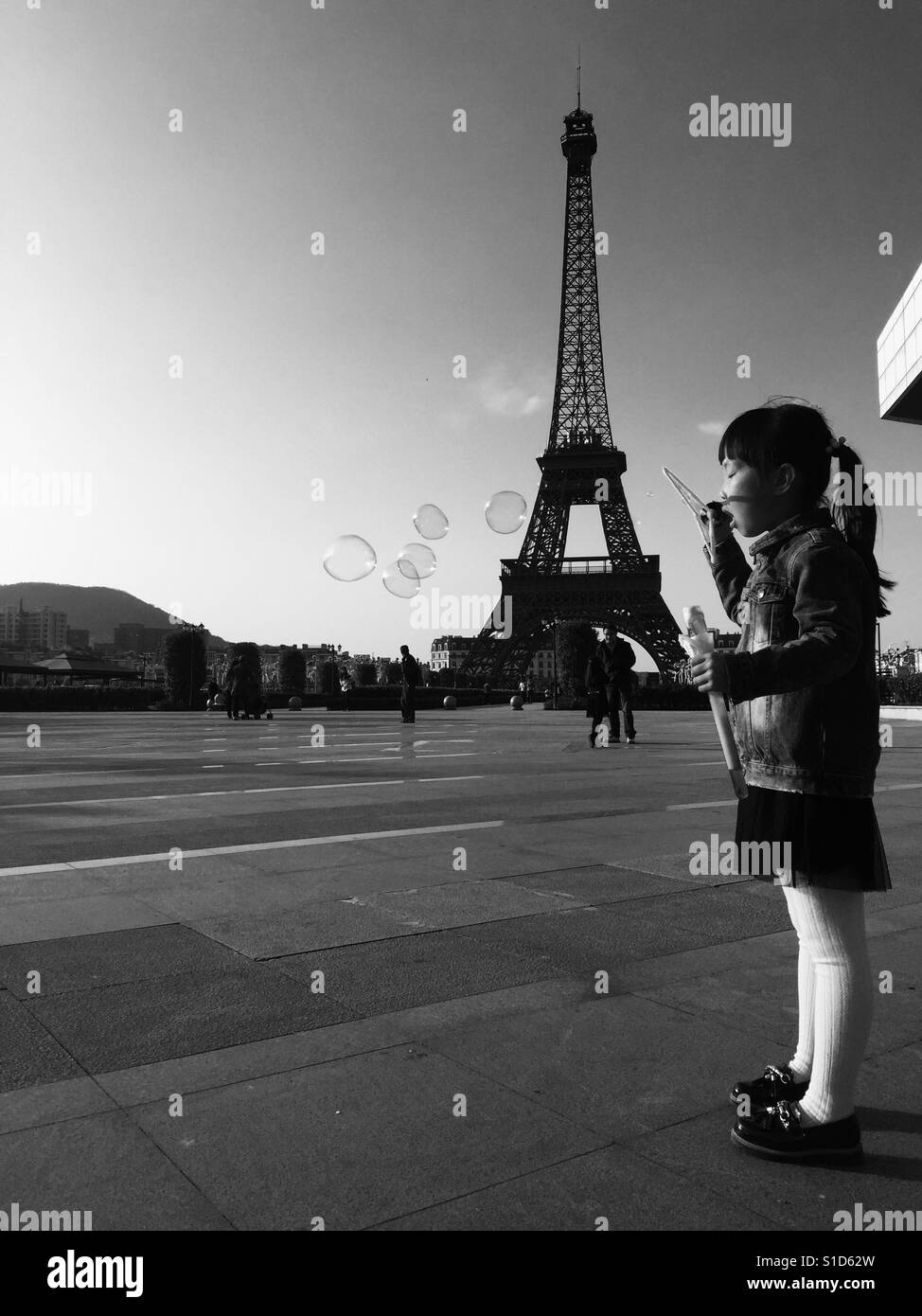Bei meinem Besuch in den Eiffelturm sehen ich sah dieses kleine Mädchen bläst Seifenblasen und die Sonne schien auf ihr Gesicht Stockfoto