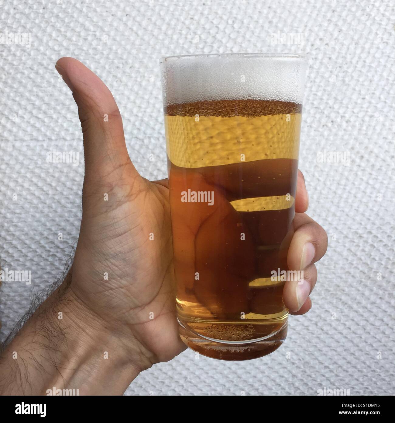 Knackig und erfrischend Lager Bier in der hand - Smartphone-aufgenommenes Stockfoto