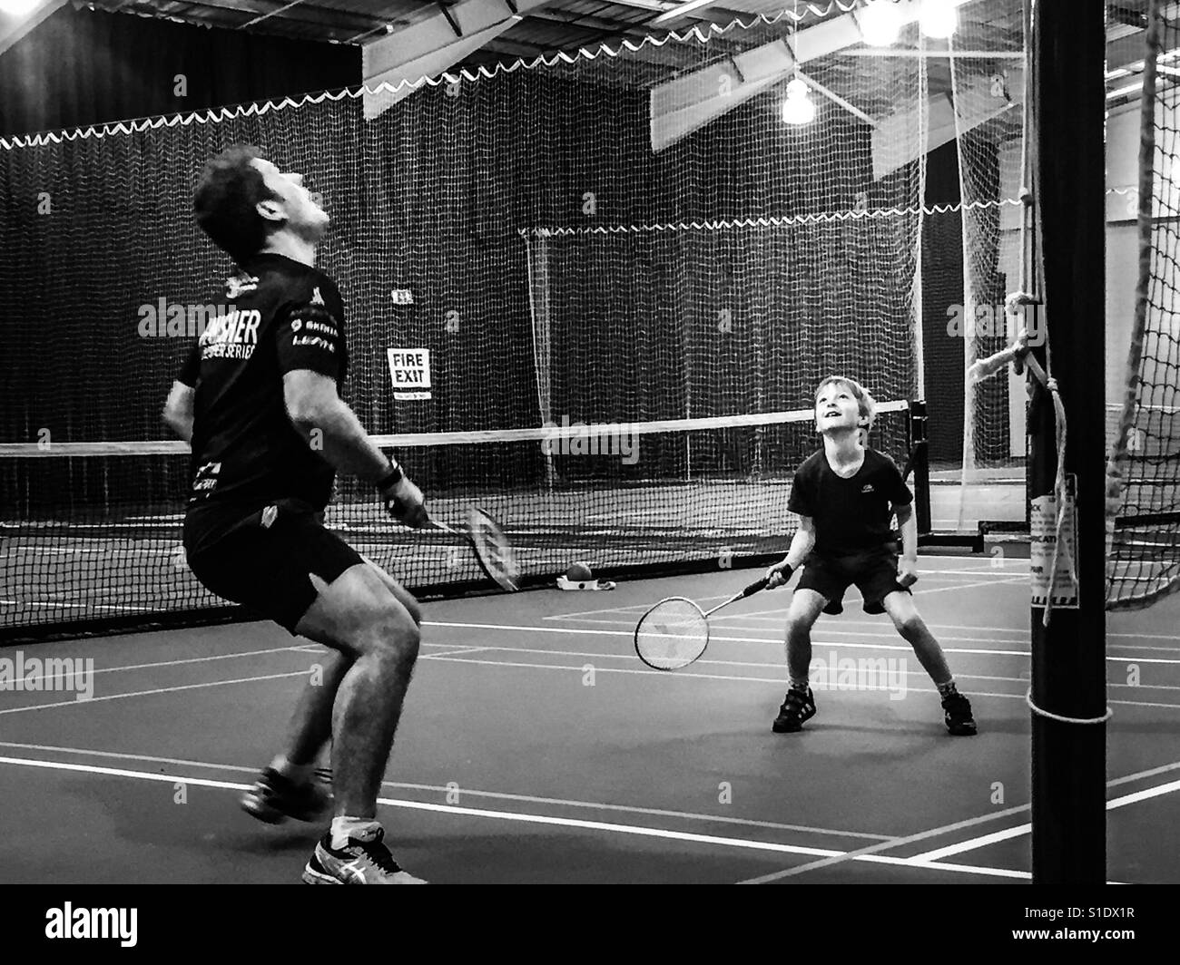 Vater und Sohn spielen Badminton Doppel. Stockfoto