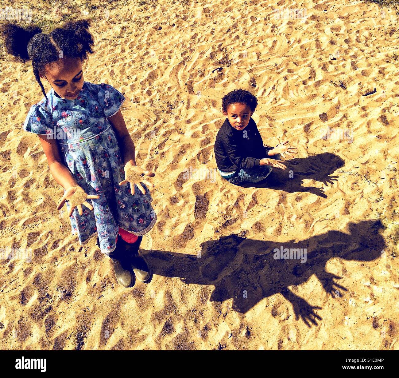 Kinder machen Schatten auf dem Sand. Stockfoto