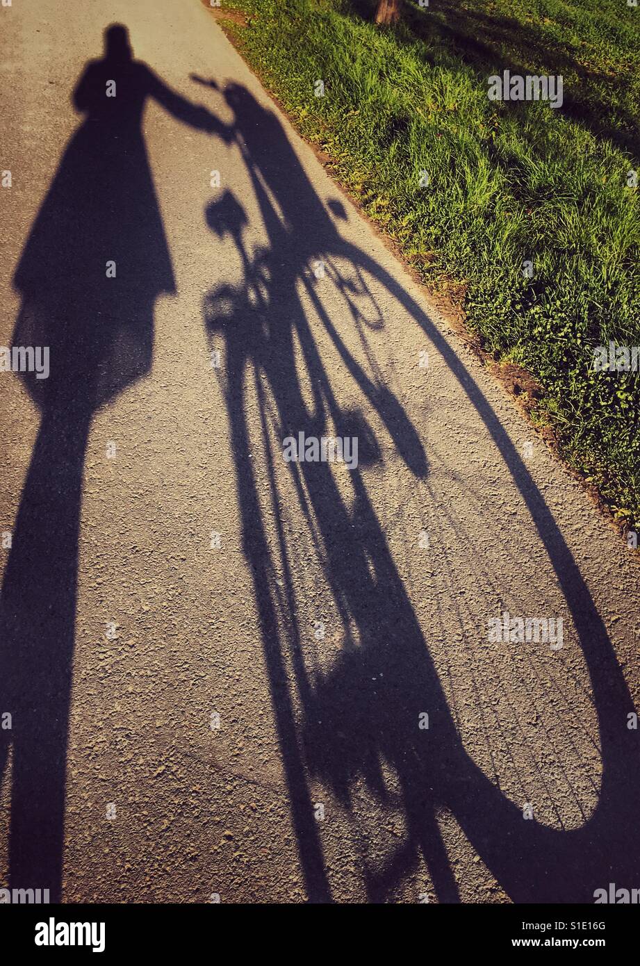 Silhouette eines Mädchens und ein Fahrrad Stockfoto