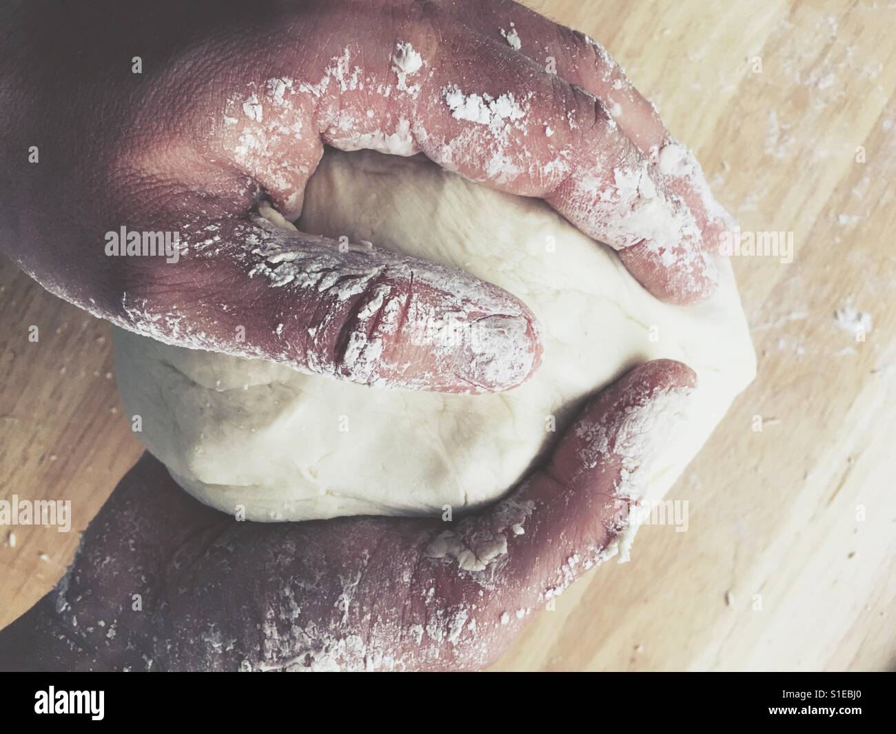 Männliche Hände kneten gesäuert Teig - Smartphone-aufgenommenes Stockfoto