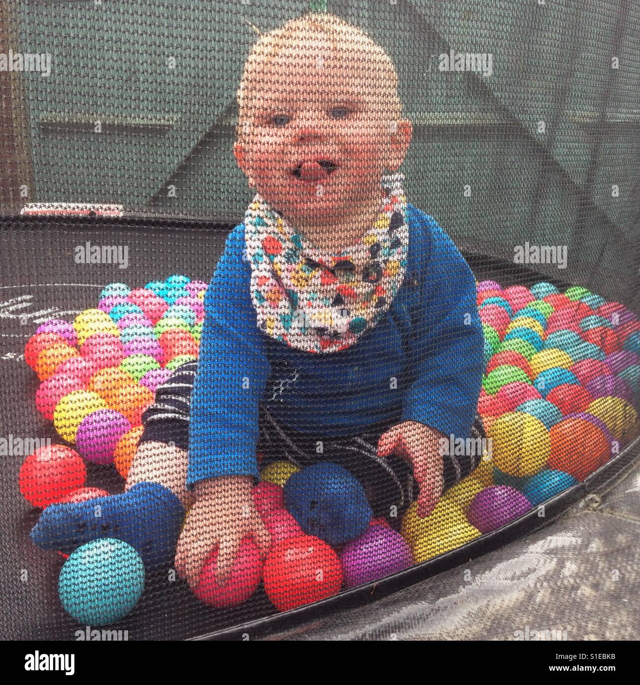 Acht Monate altes Baby junge auf einem gigantischen Trampolin Stockfoto