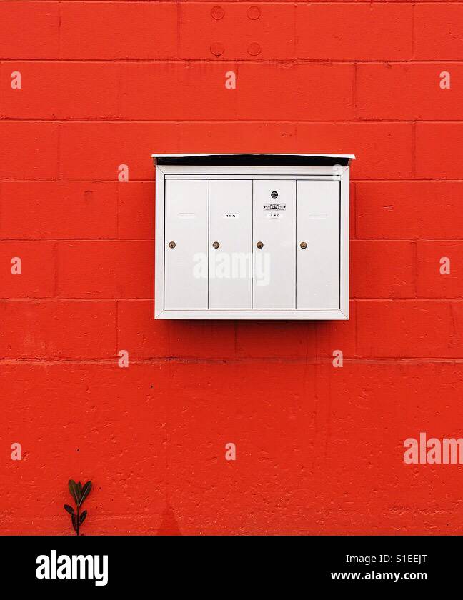Postfächer einer kühnen farbigen Orange/rote Wand Stockfoto