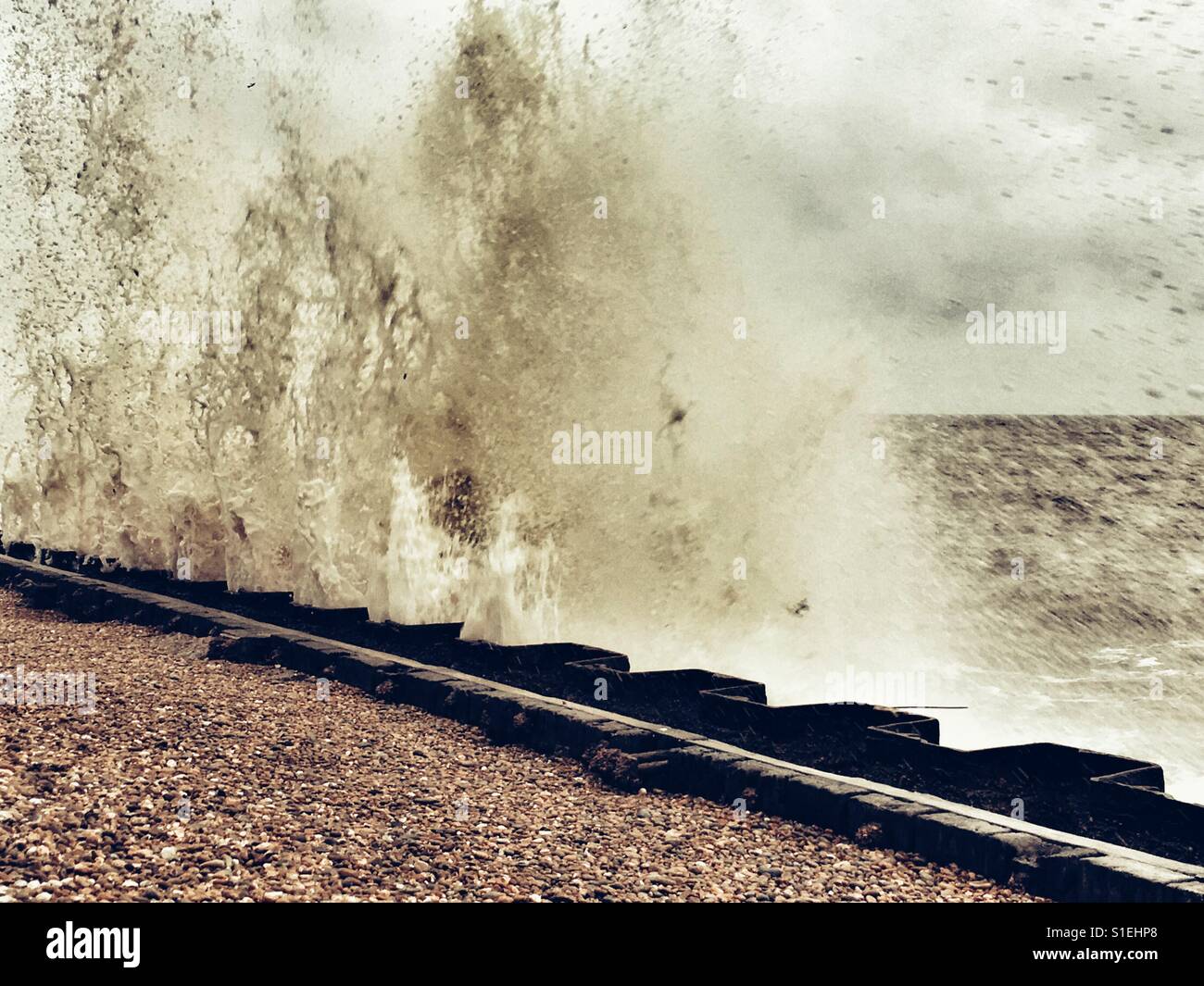 Nordsee-Wellen, die auf Ufermauer Bawdsey Ferry Suffolk UK - Smartphone-aufgenommenes Stockfoto