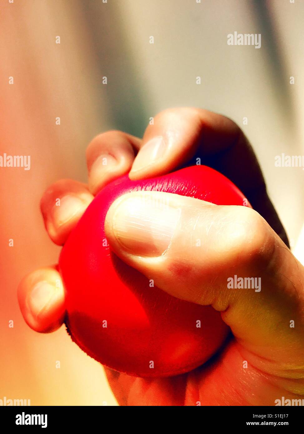 Stress-Ball gequetscht von kaukasischen Mann, USA - Smartphone-aufgenommenes Stockfoto