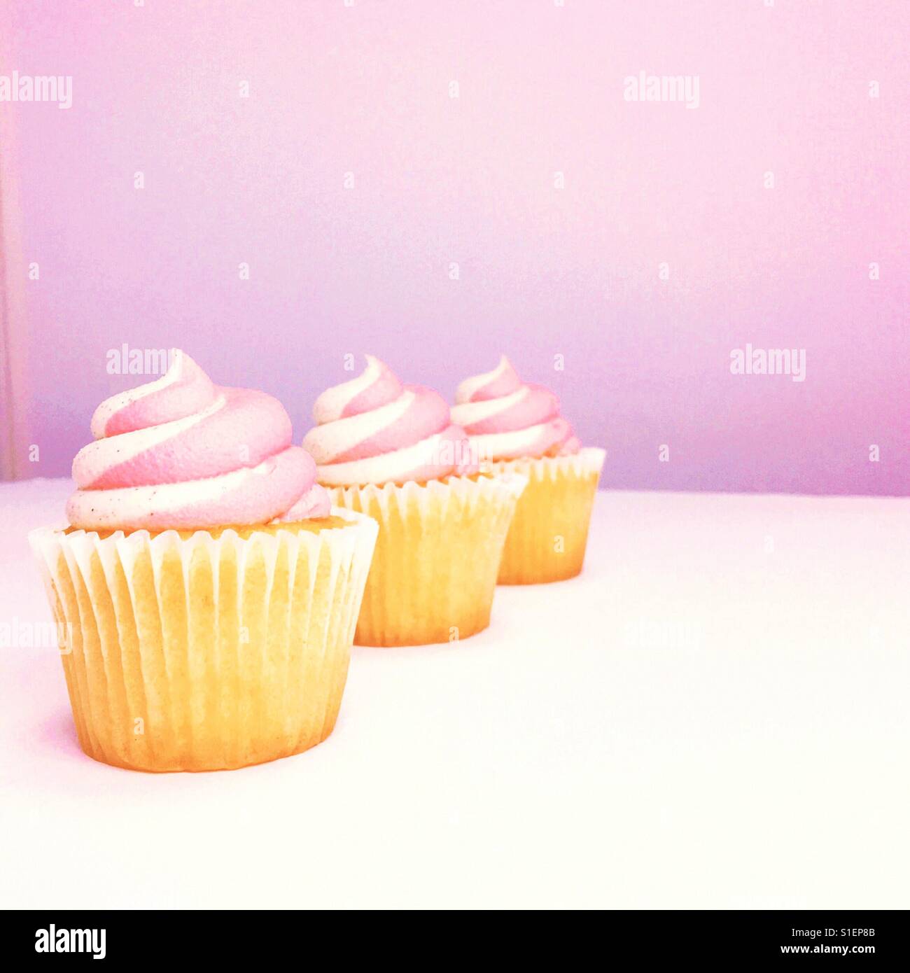 Drei Erdbeer Vanille Cupcakes. Platz für Kopie. Stockfoto