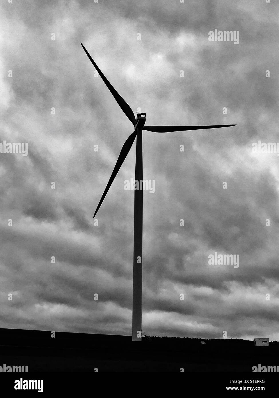 Hochenergetische Fliegen macht: eines der Windenergieanlagen mit einer erwarteten Sturm im Hintergrund auf der französischen Strecke in die Schweiz - Smartphone-aufgenommenes Stockfoto
