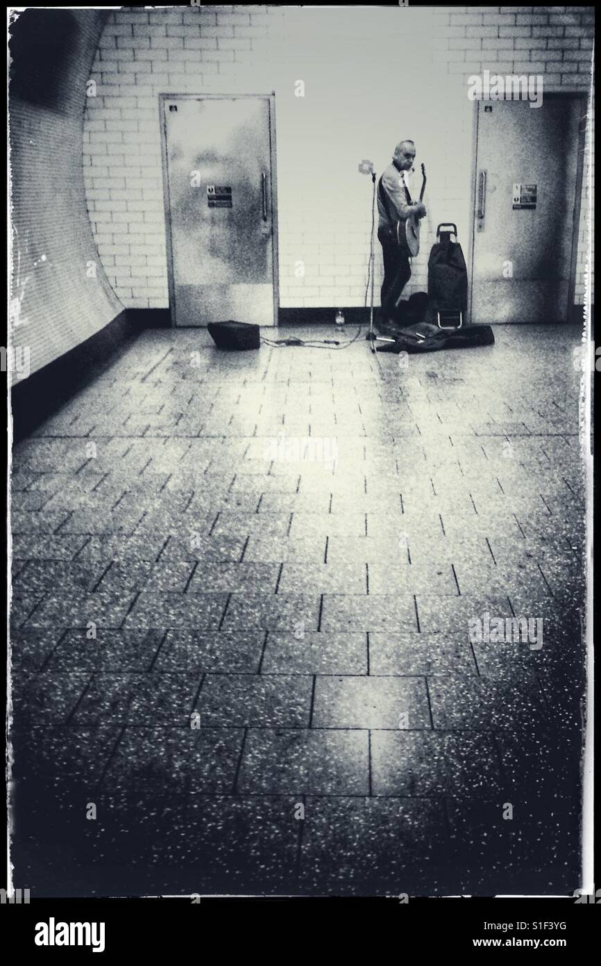 Busker am Ende eines Tunnels der Londoner U-Bahn - Smartphone-aufgenommenes Stockfoto