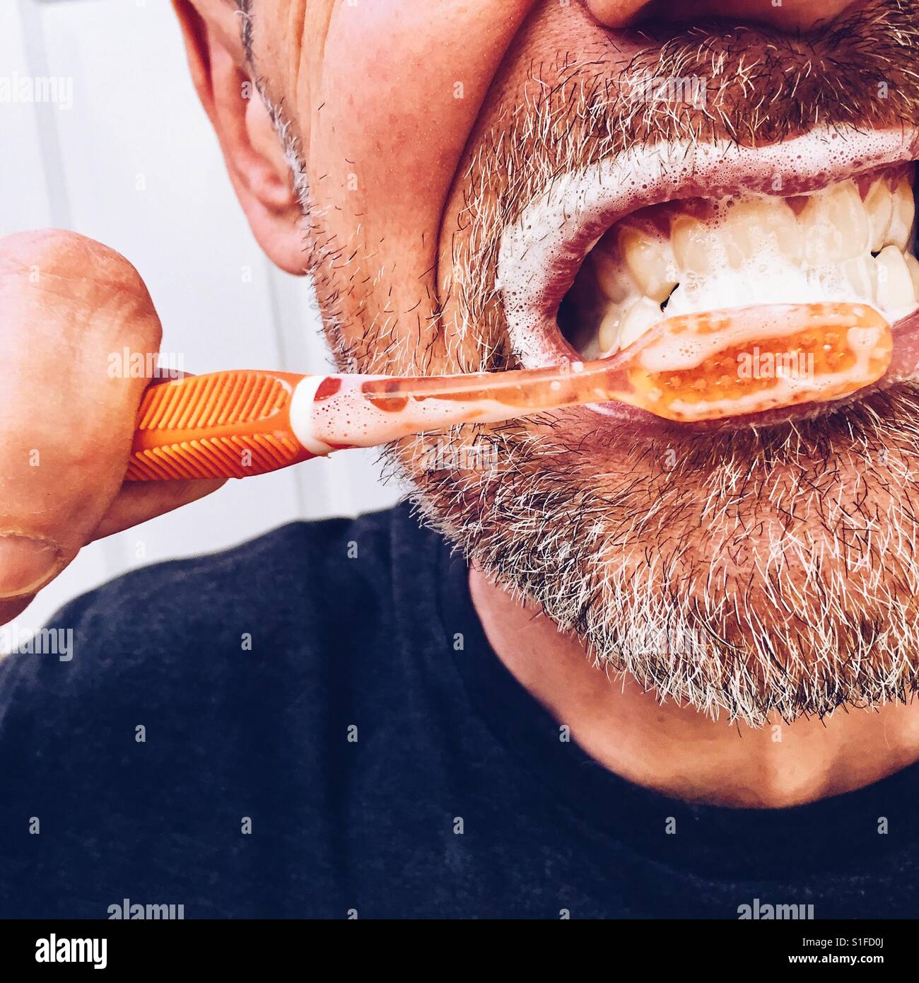 Eine verkürzte Nahaufnahme eines reifen Mannes, seine Zähne zu putzen Stockfoto