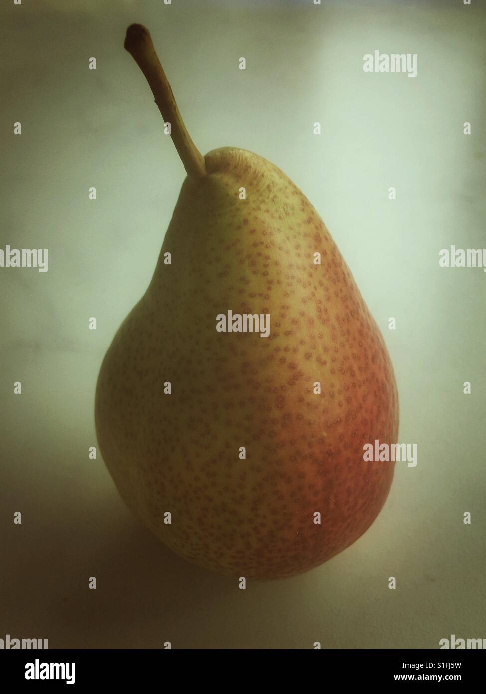 Ein Erröten Birne auf einem Marmor Oberfläche - Smartphone-aufgenommenes Stockfoto
