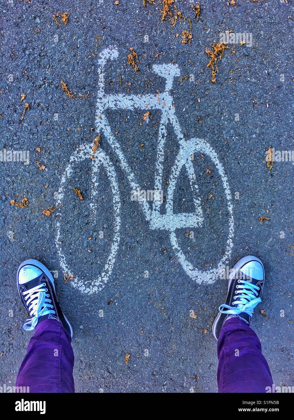 Füße mit Turnschuhen Stand in der Nähe ein Fahrrad auf der Straße zu unterzeichnen Stockfoto