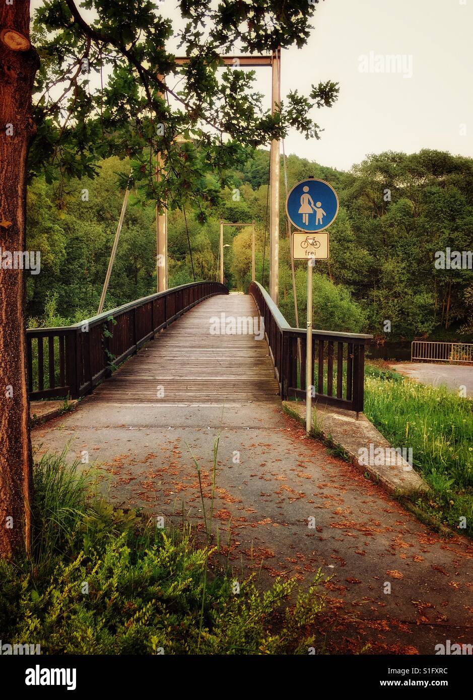 Aussicht auf eine Brücke in der Natur und ein Verkehrszeichen von Mutter und Kind und Fahrräder kostenlos Stockfoto