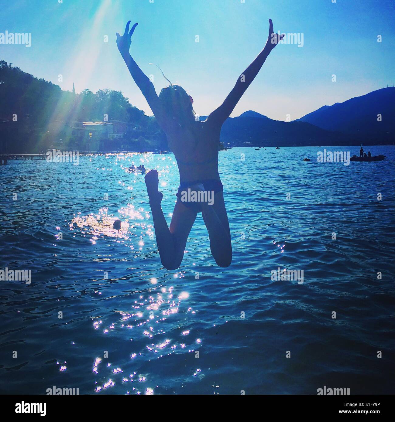 Mädchen, die einen Sprung in den Gardasee Stockfoto