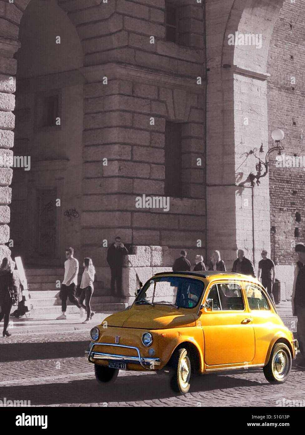 Gelber Fiat 500 Farbe spritzte in eine schwarze und weiße Szene mit Torbögen Stockfoto