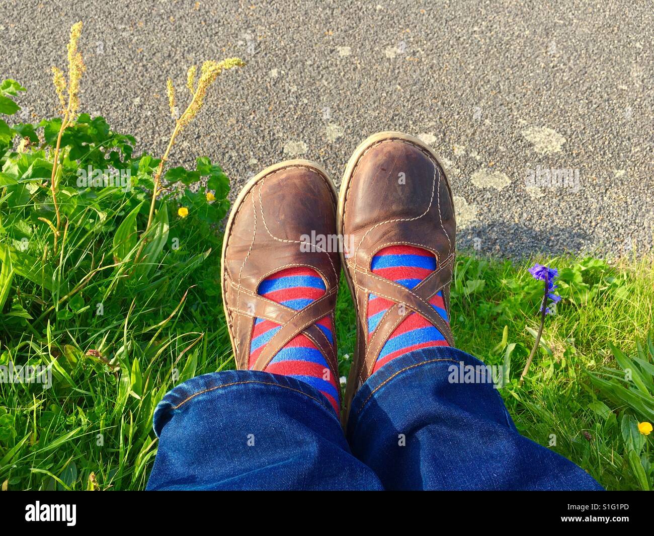 Füße in Schuhen ruhen auf dem Rasen Stockfoto