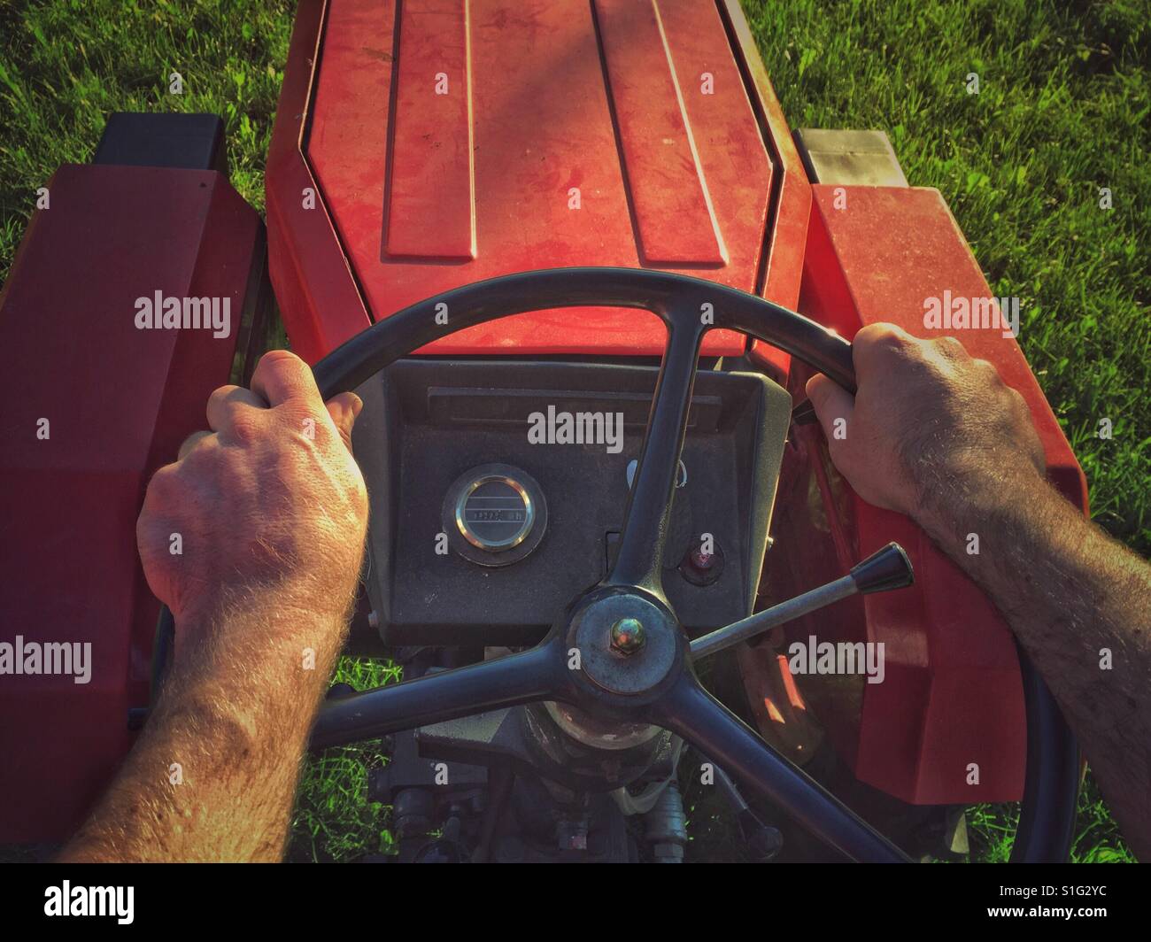 Hände eines Mannes am Lenkrad Traktor fahren Stockfoto