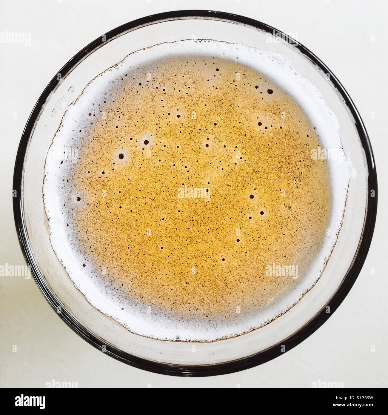 leicht schäumende Bier in einem Glas geschossen von oben machen einen Kreis - Smartphone-aufgenommenes Stockfoto
