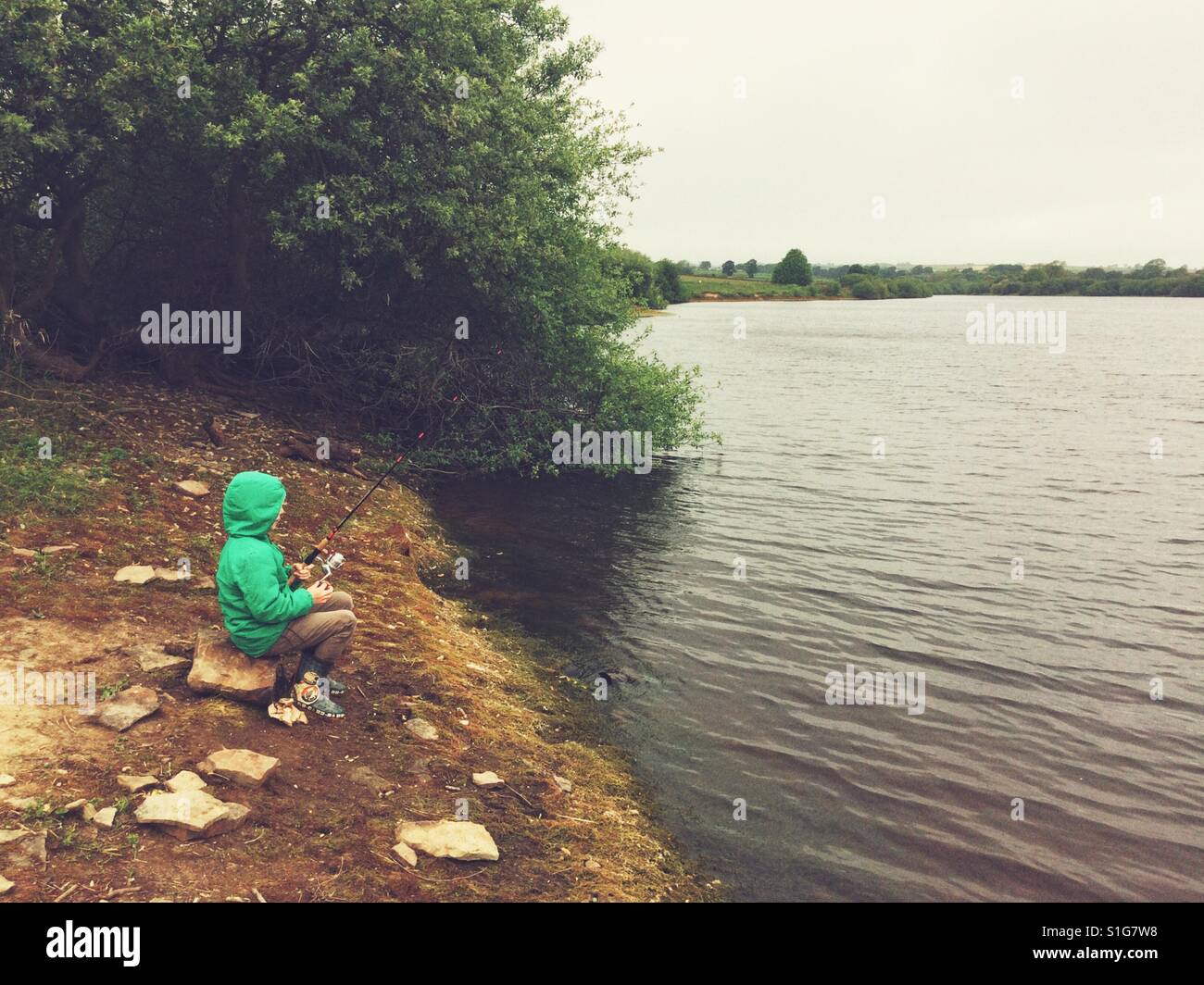 Acht Jahre alter Junge Angeln am Deich Scout Reservoir Penistone, Barnsley, South Yorkshire, England, Vereinigtes Königreich. Stockfoto