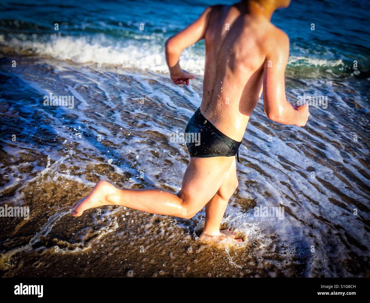 Junge Silhouette Runnning und spielen am Strand in el Maresme Küste. Provinz Barcelona, Catalonia Stockfoto