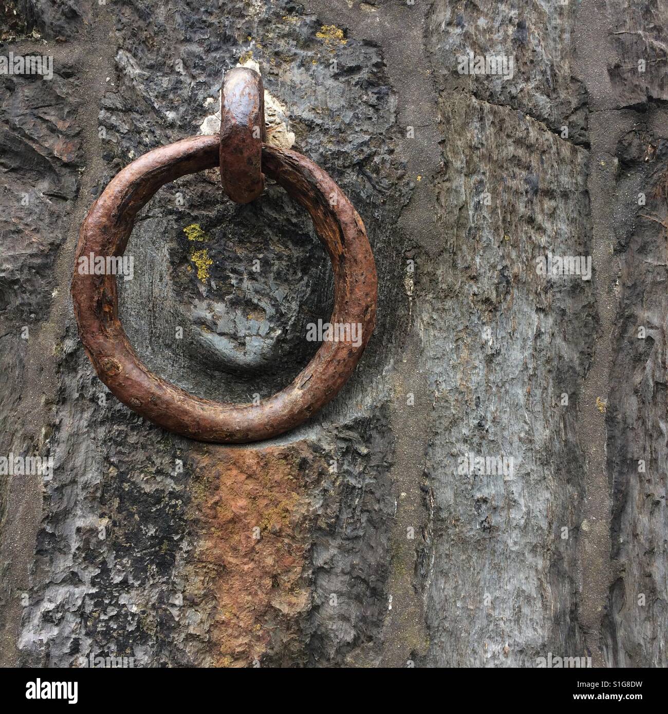 Eine rostige alte Liegeplatz-Ring auf der Hafenmauer bei Polkerris, Cornwall Stockfoto