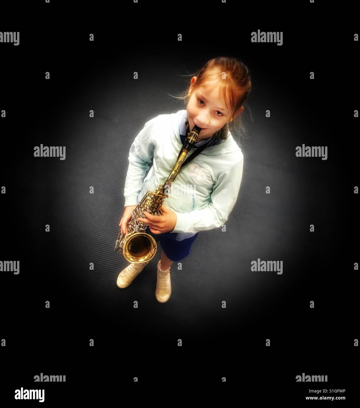 Schen Mädchen spielt Saxophon. Stockfoto